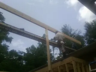 Carpenter setting a ridge beam over a new addition frame — Ice Dam Removal by Roofing Brothers in Rancho Santa Margarita