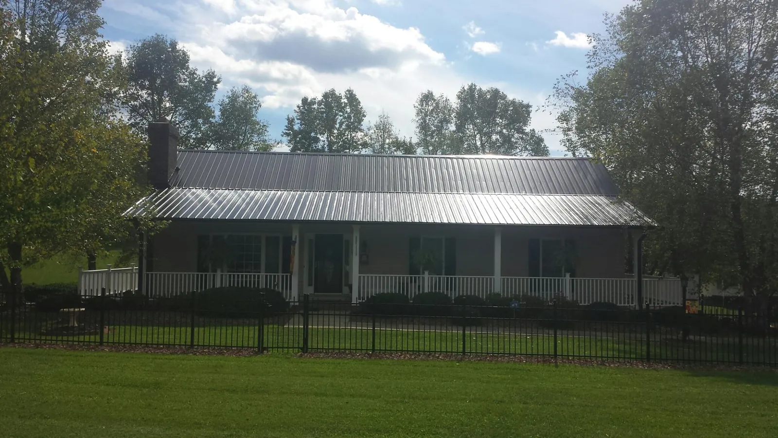Gray metal roof on a brick ranch with a full width front porch — Gutter Guard Installation work by our crew in Rancho Santa Margarita