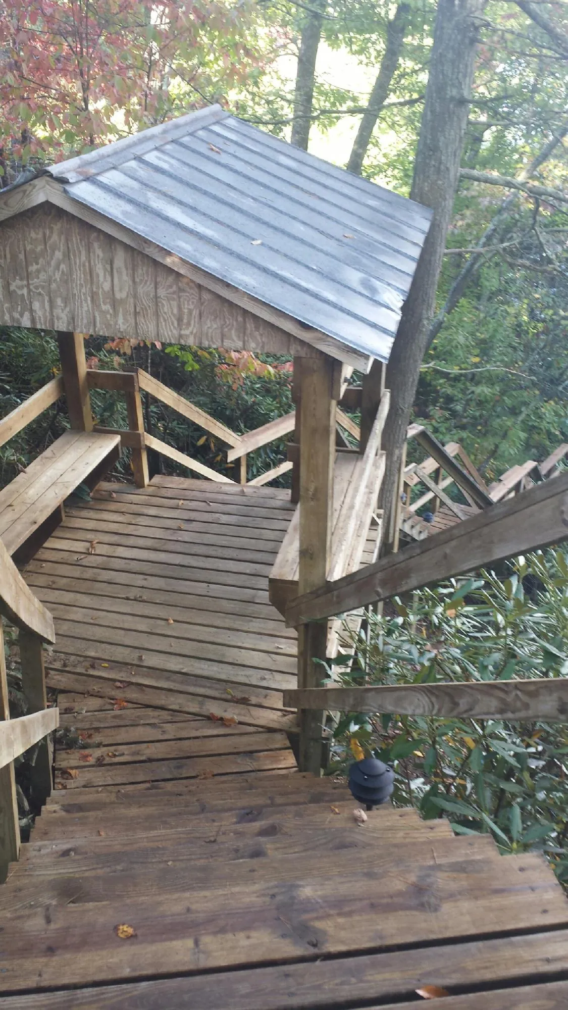 Metal roofed shelter over wooden steps on a wooded walkway — Skylight Repair & Installation work by our crew in Rancho Santa Margarita